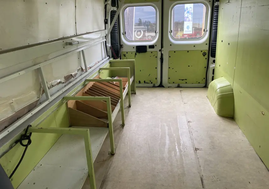 Intérieur du Citroën Jumper L3H2 2011 vu de l'avant vers les portes arrière, avec aménagements verts usés sur les côtés.