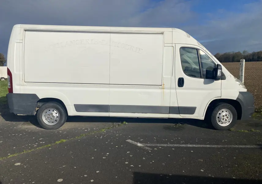 Vue latérale gauche d'un utilitaire blanc Citroën Jumper L3H2 2011 avec marquage effacé sur la caisse.
