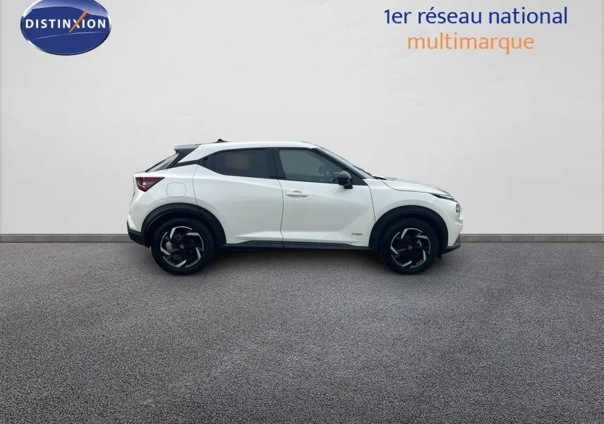 Profil droit d'un Nissan Juke blanc nacré 2024, finition N-Connecta avec jantes noires bicolores.