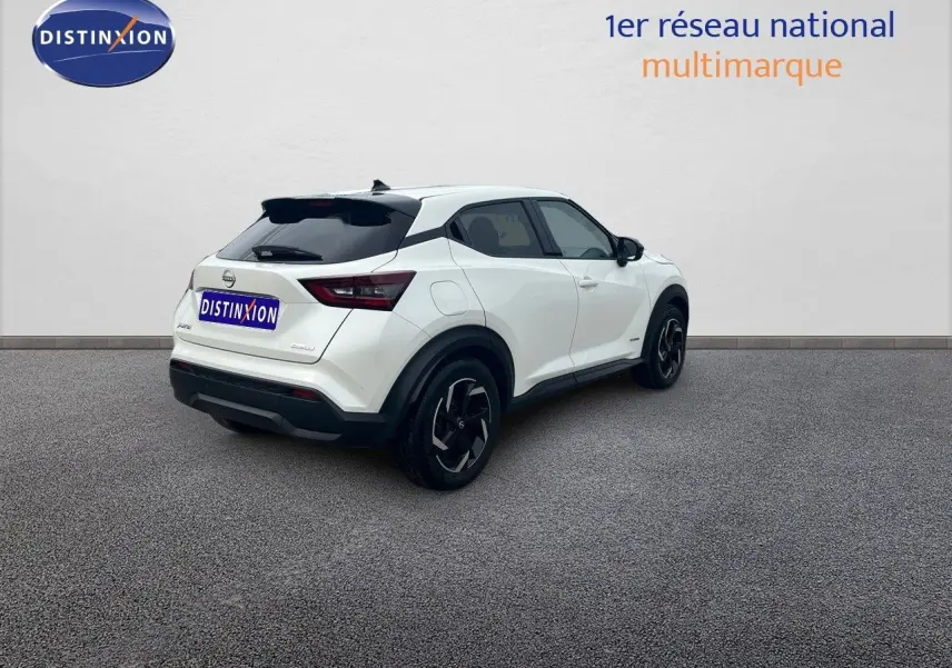Nissan Juke blanc nacré métal vu en 3/4 arrière droit, soulignant ses jantes noires et lignes modernes.