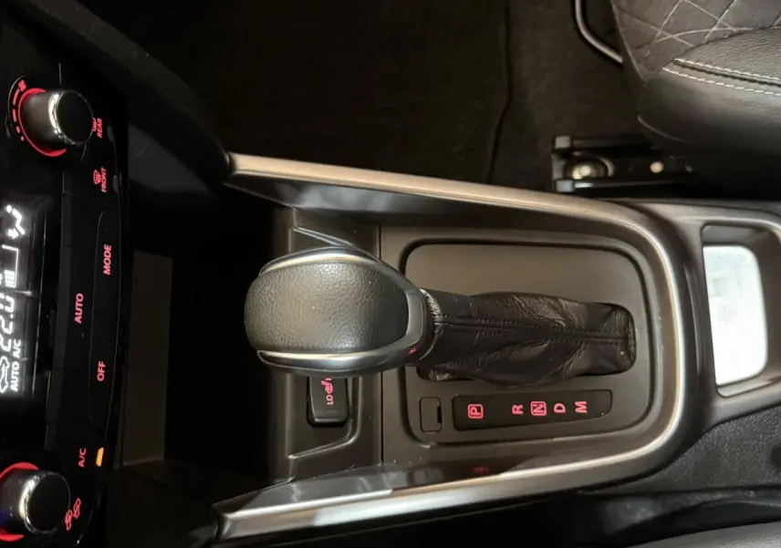 Le levier de vitesses automatique noir du Suzuki Vitara 1.5 Dualjet hybrid STYLE vu de dessus avec console centrale.