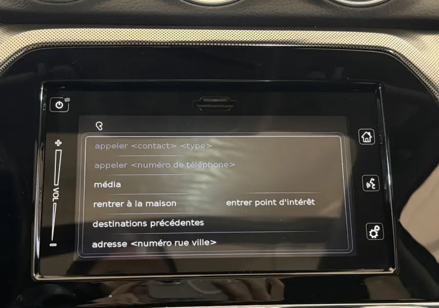 Écran tactile central du tableau de bord du Suzuki Vitara noir 2022 affichant le menu vocal de navigation et médias.