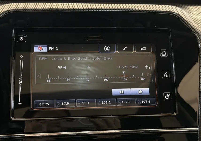 Écran tactile central du tableau de bord du Suzuki Vitara noir 2022 affichant la radio FM 103,9 MHz.