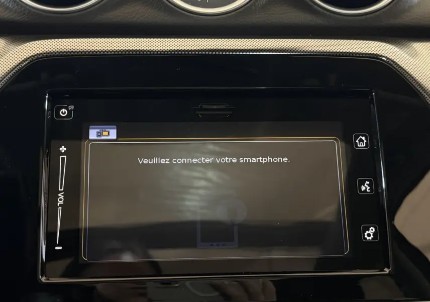 Écran tactile central noir affichant "Veuillez connecter votre smartphone" dans l'habitacle du Suzuki Vitara noir.