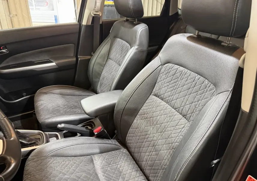 Vue intérieure rapprochée des sièges avant noirs en cuir et tissu du Suzuki Vitara 1.5 Dualjet hybrid STYLE 2022.