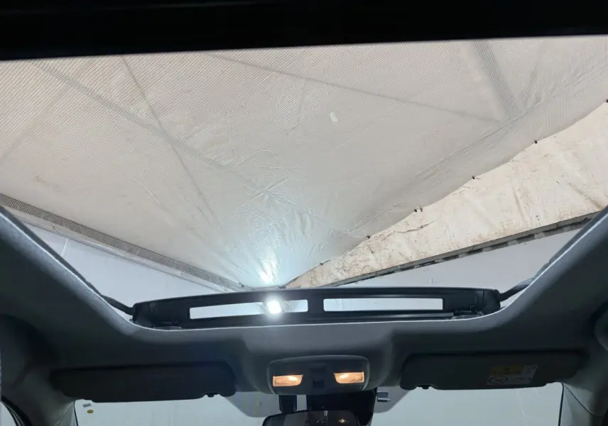 Toit ouvrant panoramique électrique ouvert vu de l'intérieur avant du Suzuki Vitara noir 2022.