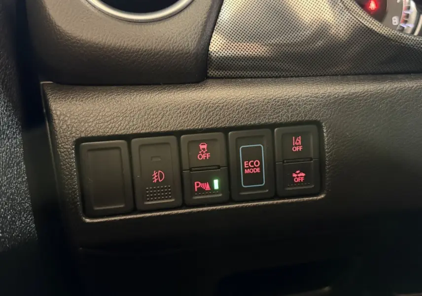 Gros plan sur les commandes du tableau de bord du Suzuki Vitara noir 2022, avec boutons d'assistance et mode ECO éclairés.