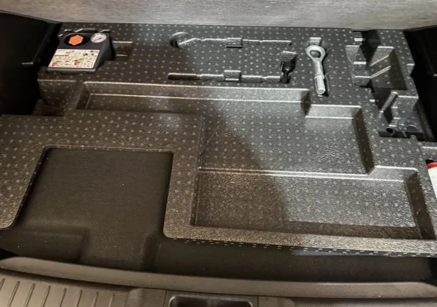 Rangement en mousse noire dans le coffre du Suzuki Vitara 1.5 Dualjet hybrid STYLE AT 2022, avec outils intégrés.