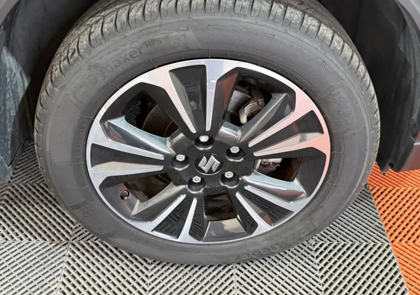 Gros plan sur la jante alliage bicolore noire et argentée avec logo Suzuki du Suzuki Vitara 2022 noir.