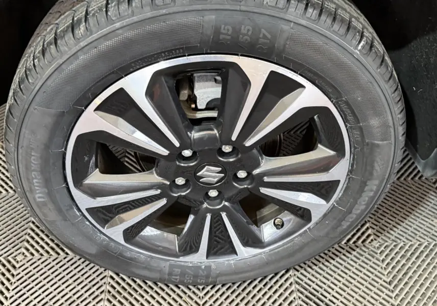 Gros plan sur la jante alliage noire et argentée du Suzuki Vitara 1.5 Dualjet hybrid STYLE 2022 avec logo central Suzuki.