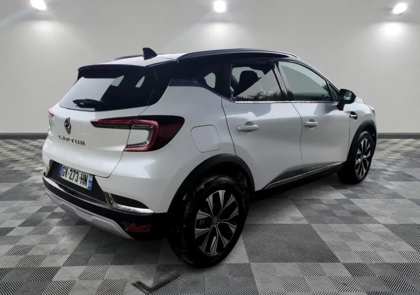 Vue 3/4 arrière droite d’un Renault Captur blanc avec toit noir et jantes alliage 18 pouces Pasadena diamantées.