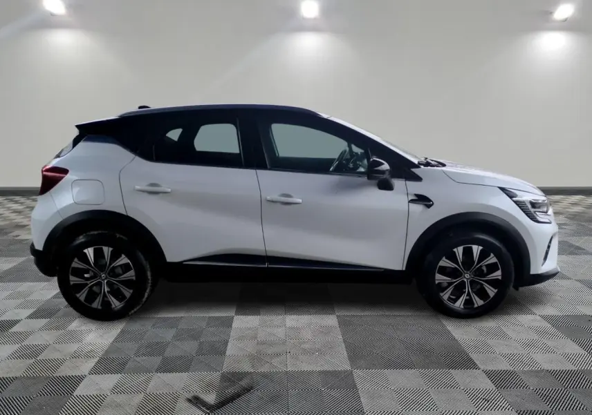 Profil droit du Renault Captur blanc avec toit noir et jantes alliage 18 pouces Pasadena diamantées.