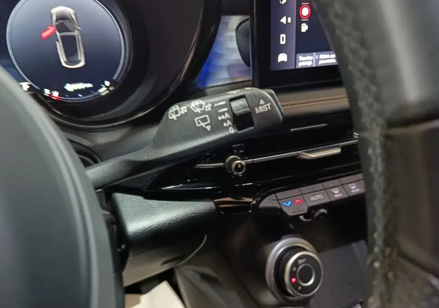 Gros plan sur la commande d’essuie-glace et le tableau de bord noir de l’Alfa Romeo Tonale bleu, avec écran tactile visible.