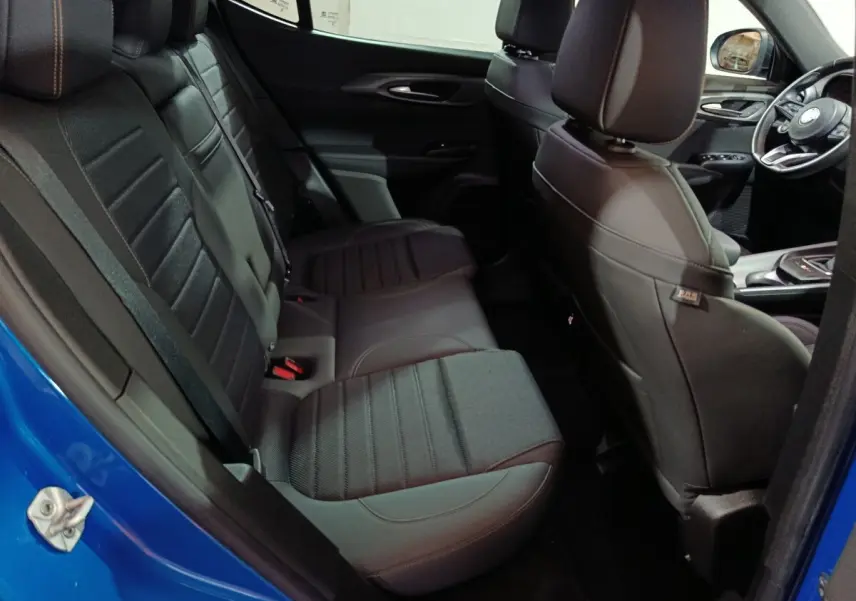 Vue intérieure côté gauche montrant la banquette arrière noire et partie avant du siège conducteur d'une Alfa Romeo Tonale bleu 2023.