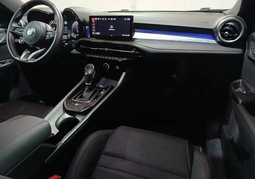 Vue intérieure côté conducteur de l'Alfa Romeo Tonale bleu, avec tableau de bord digital et console centrale moderne.