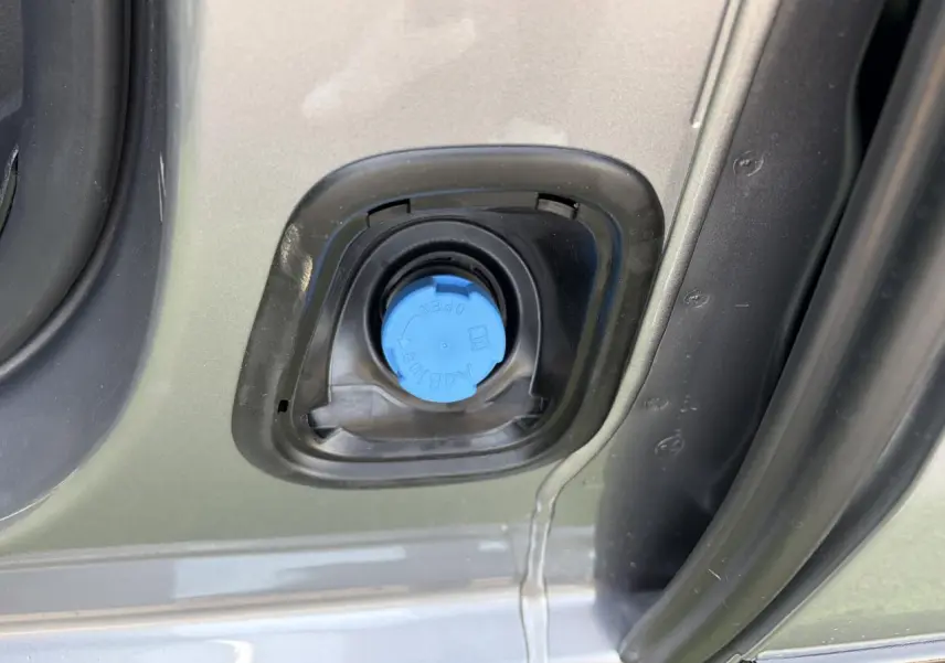 Gros plan sur le bouchon bleu AdBlue du réservoir d’un Citroën Jumpy gris acier métal, côté gauche ouvert.