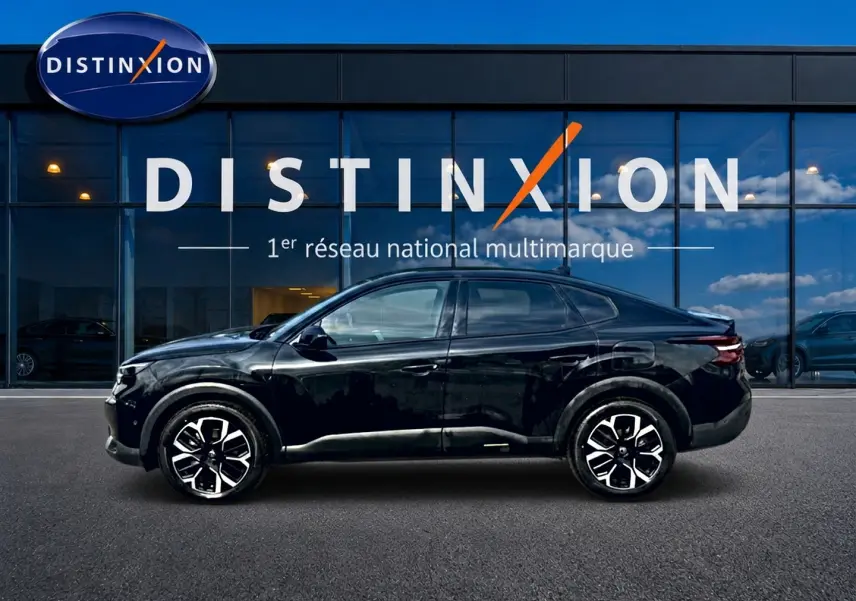 Vue latérale droite d'une Citroën C4 X noire 2025 avec jantes alliage et silhouette élancée devant un showroom Distinxion.