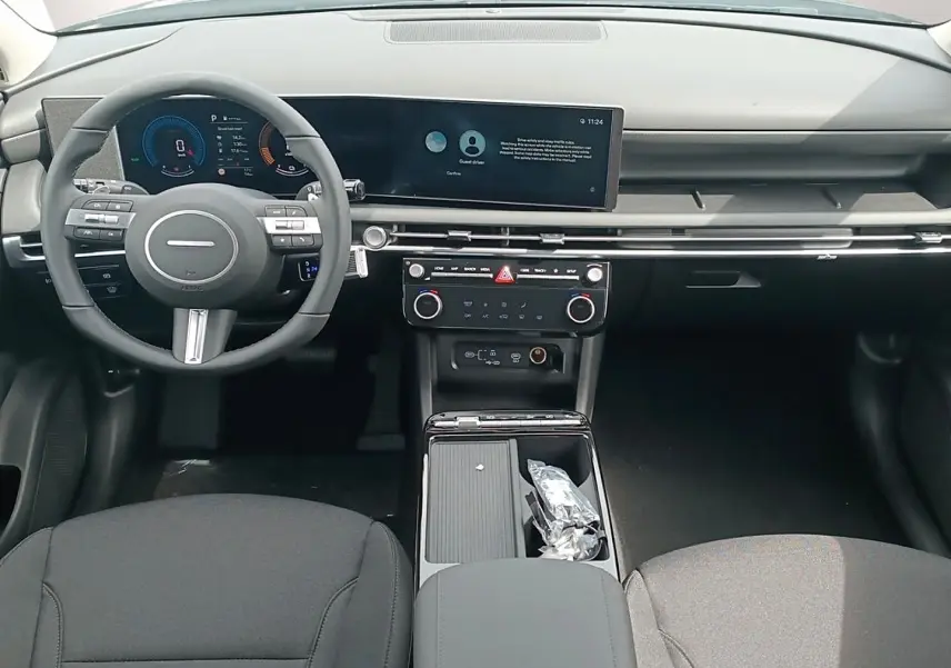 Vue intérieure avant du Hyundai Tucson 2026 gris ecotronique, avec tableau de bord numérique et écran tactile large.