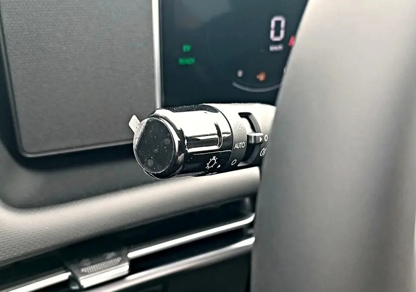 Gros plan sur la manette de commande des phares à gauche du volant du Hyundai Tucson gris écotronique 2026.