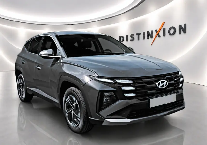 Vue 3/4 avant du Hyundai Tucson 2026 gris ecotronique avec calandre noire et jantes alliage 17 pouces.