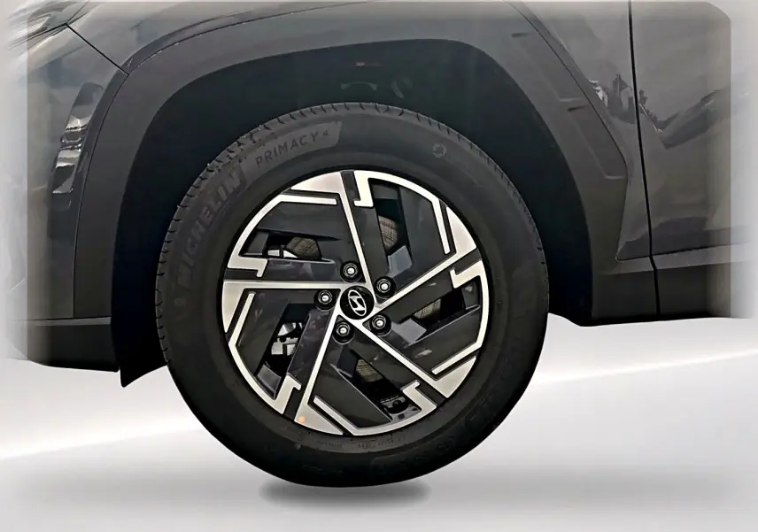 Gros plan sur la roue avant gauche du Hyundai Tucson gris ecotronique avec jante alliage 17 pouces au design moderne.