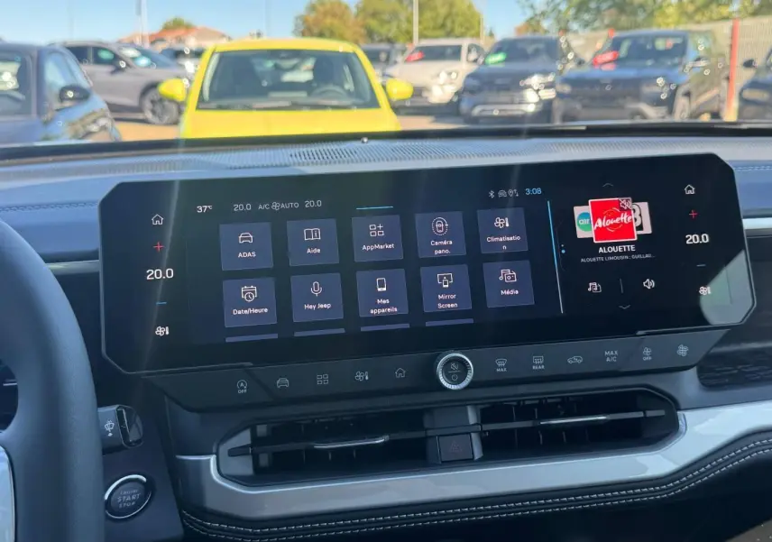 Vue intérieure du tableau de bord du Jeep Compass 2026 avec écran tactile large et finitions en tissu gris anthracite.