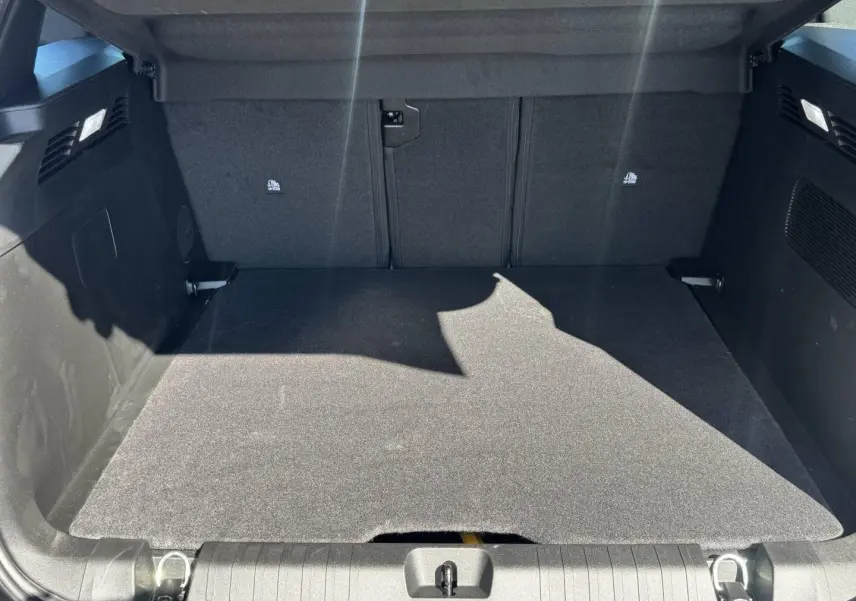 Vue intérieure du coffre spacieux et propre du Jeep Compass 2026, revêtement noir uniforme sans objet visible.