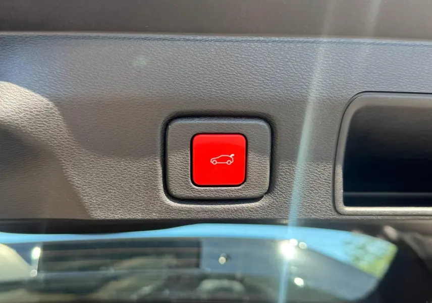 Bouton rouge d'ouverture électrique du coffre sur panneau intérieur du Jeep Compass Vulcano 2026.