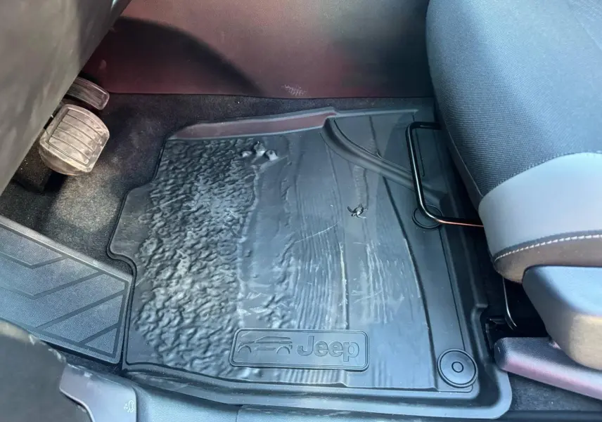 Gros plan sur le tapis de sol noir côté conducteur du Jeep Compass 2026, avec logo Jeep embossé visible.