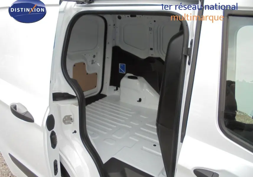 Vue intérieure du fourgon Ford Transit Courier blanc glacier, montrant l'espace de chargement vide avec porte latérale ouverte.