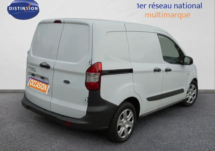 Vue 3/4 arrière droite d'un Ford Transit Fourgon Courier blanc glacier avec portes arrière battantes et protections noires.