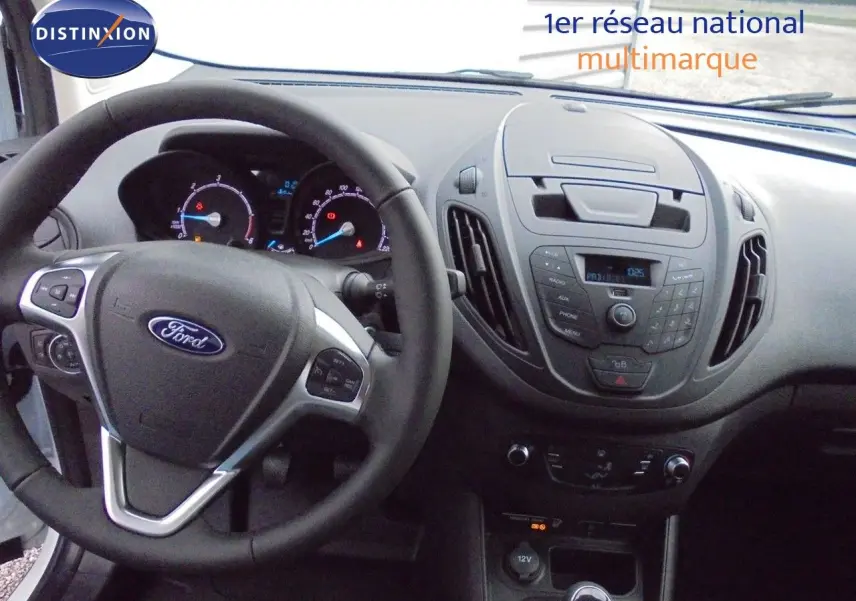 Intérieur du Ford Transit Courier 2022, tableau de bord et volant vus de face, finition noire avec commandes intégrées.