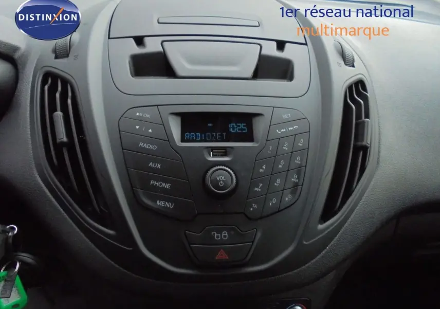 Vue rapprochée du tableau de bord noir du Ford Transit Courier 2022 avec console centrale et commandes radio.