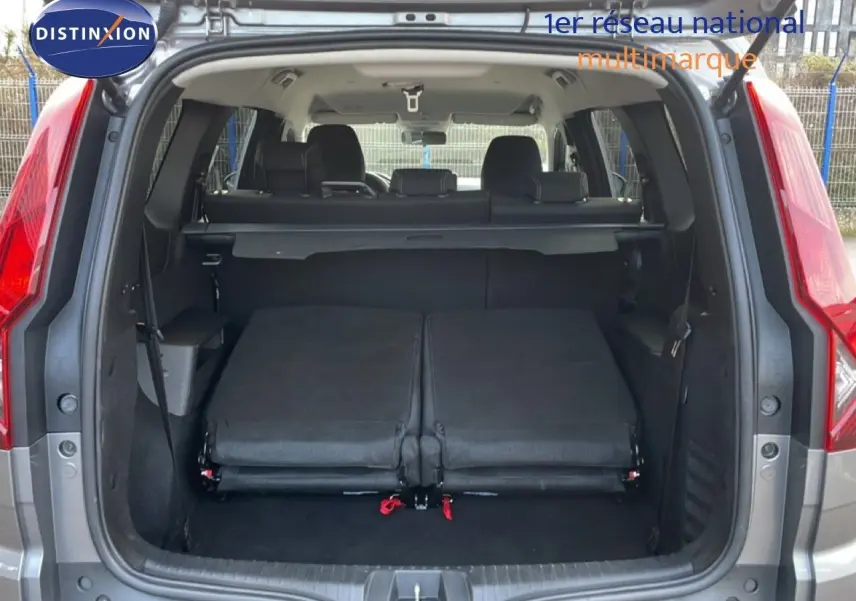 Vue arrière ouverte du Dacia Jogger gris schiste métal 2025, montrant les sièges arrière rabattus et le coffre spacieux.