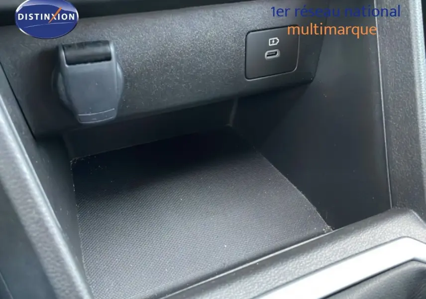 Vue rapprochée de la console centrale noire du Dacia Jogger 2025, montrant un port USB et une prise 12V.