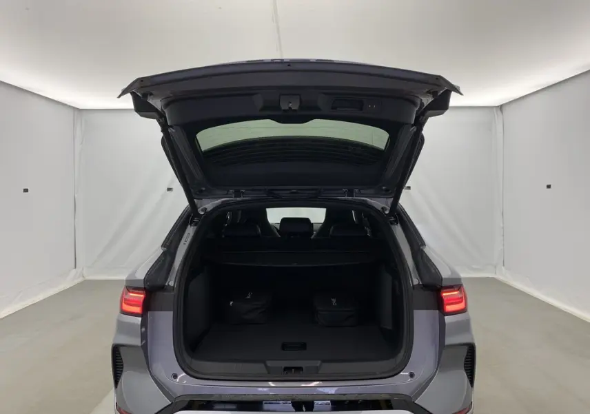 Vue arrière du coffre ouvert du BYD SEAL U Time Grey 2025, avec feux LED allumés et deux sacs noirs à l'intérieur.