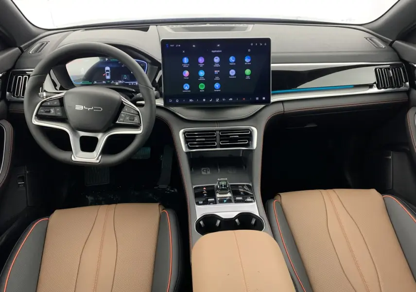 Vue intérieure avant du BYD SEAL U 2025 avec tableau de bord noir, écran tactile central et sièges cuir marron.