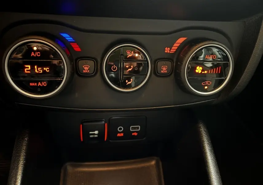 Vue rapprochée du tableau de bord noir du Fiat Tipo 2017, montrant les commandes de climatisation et prises USB/AUX.