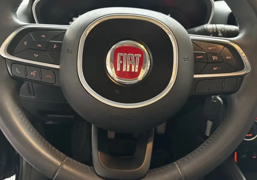 Gros plan sur le volant cuir et alu noir du Fiat Tipo 2017 avec commandes multifonctions intégrées.