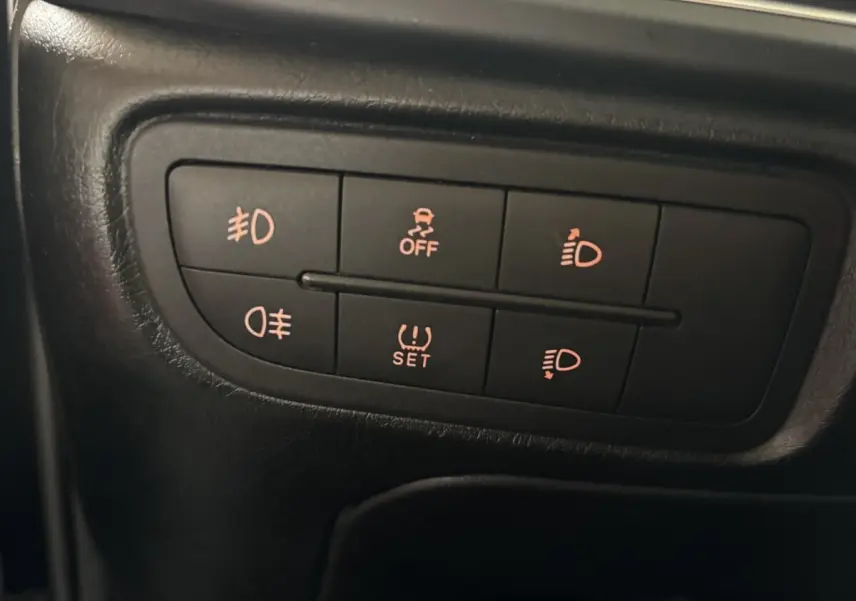 Gros plan sur les commandes d’éclairage et d’ESP du tableau de bord d’une Fiat Tipo noire de 2017.