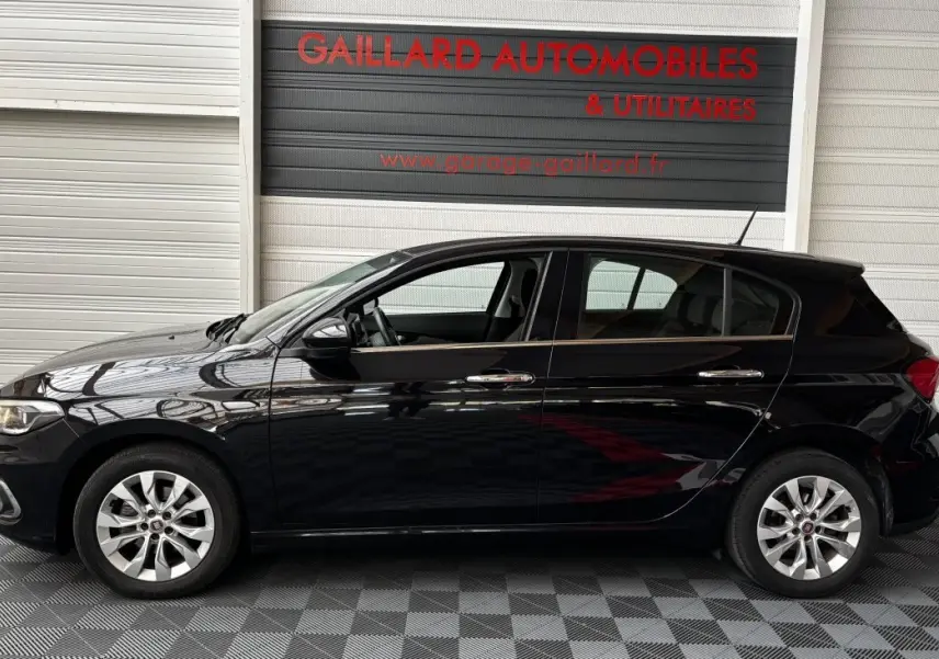 Profil latéral gauche d'une FIAT TIPO noire 2017, avec jantes alliage et poignées de porte chromées.