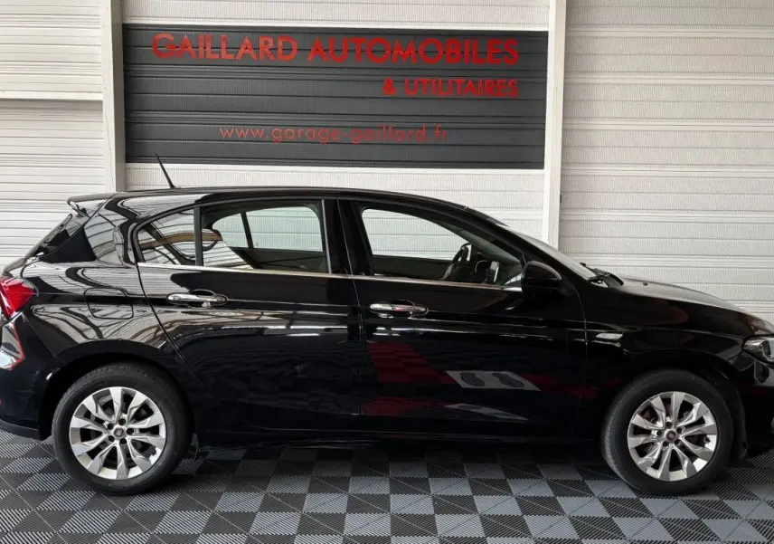 Vue latérale droite d'une FIAT Tipo noire 2017, avec jantes alliage et poignées de porte chromées.