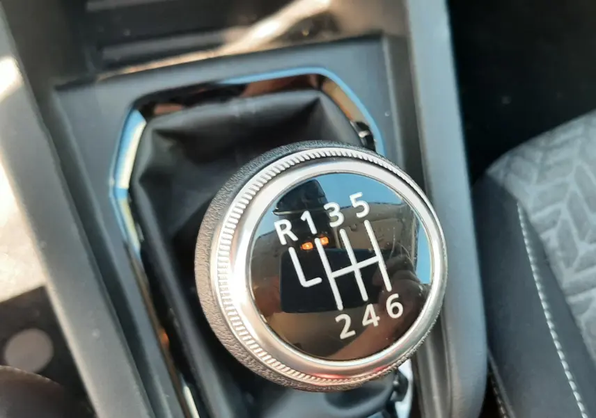 Gros plan sur le levier de vitesses manuel noir de la Renault Clio V DCI 100ch Evolution, intérieur tissu gris-noir.