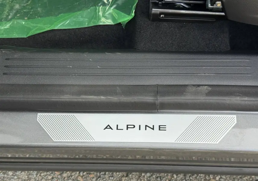 Gros plan sur la plaque de seuil de porte ALPINE du Renault Austral gris Schiste satin, intérieur noir visible.