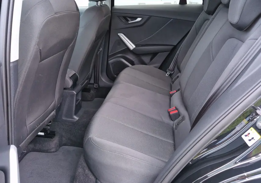 Vue intérieure côté droit sur la banquette arrière noire tissu d'un Audi Q2 35 TFSI 2023 noir mito metal.