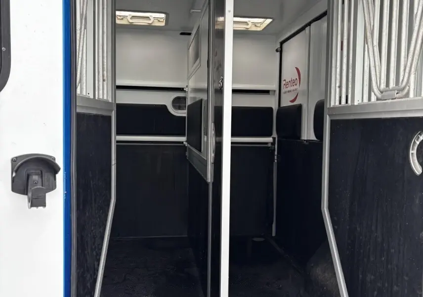 Vue intérieure arrière du Renault Master bleu 2020, montrant la cloison pleine et les compartiments de chargement.