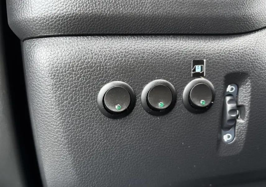 Gros plan sur les boutons de réglage noirs du tableau de bord intérieur du Renault Master bleu, côté conducteur.