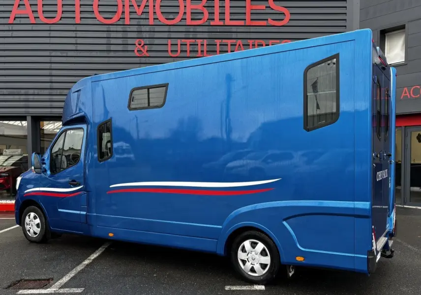 Vue latérale droite du Renault Master bleu 2020 avec fenêtres latérales et décor tricolore sur la carrosserie.