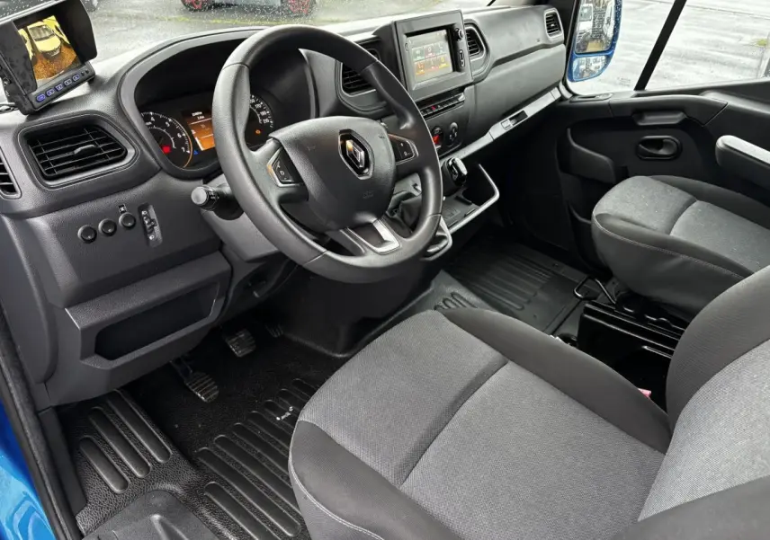 Vue intérieure côté conducteur du Renault Master 2020 bleu, montrant le volant, tableau de bord et écran central tactile.