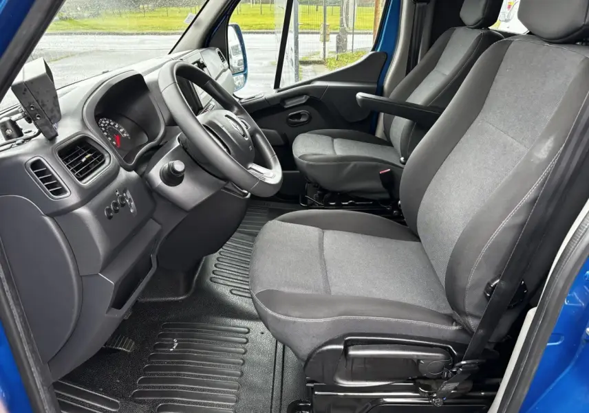 Vue intérieure côté conducteur du Renault Master bleu 2020, montrant les sièges gris et le volant réglable.